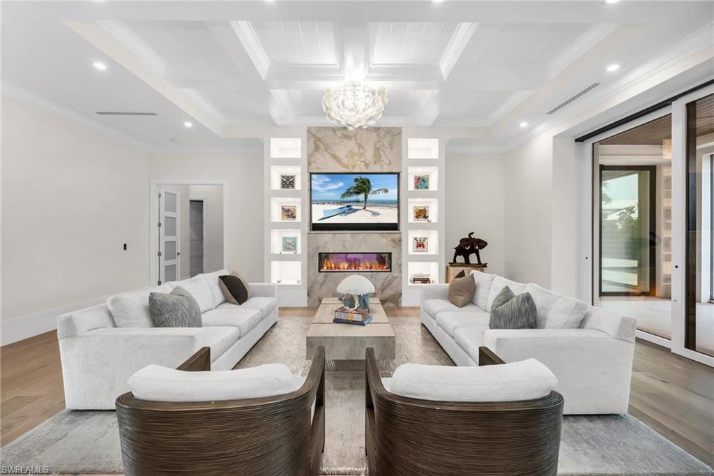 3190 Crayton Road Naples, FL 34103 - Photo 6 of 48 a living room with fireplace furniture and a chandelier