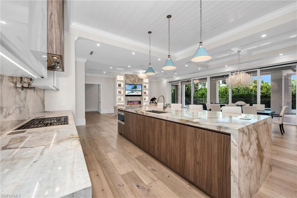 3190 Crayton Road Naples, FL 34103 - Photo 9 of 48 a kitchen with stainless steel appliances kitchen island granite countertop a sink and a wooden floors