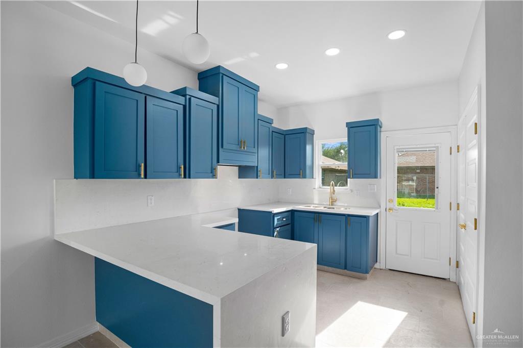 1005 Emerald Avenue Weslaco, TX 78599 - Photo 6 of 15 a kitchen with stainless steel appliances a sink a refrigerator and wooden cabinets
