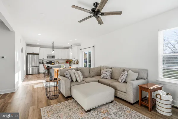 a living room with furniture and a view of kitchen
