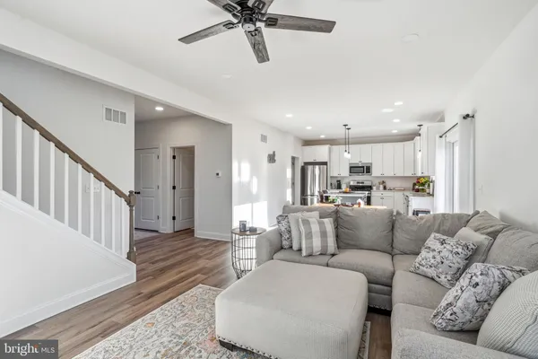 a living room with furniture and a view of kitchen