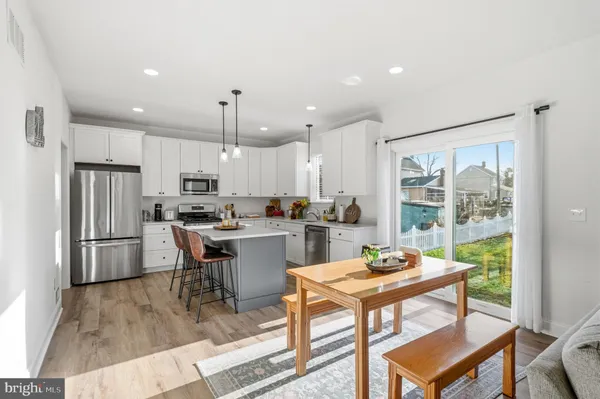 a kitchen with a dining table chairs refrigerator and cabinets