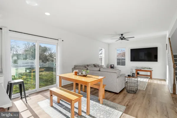 a living room with furniture a flat screen tv and a floor to ceiling window