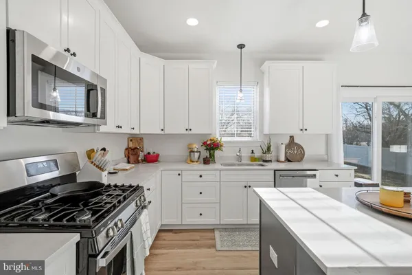a kitchen with cabinets appliances a sink and a counter top space