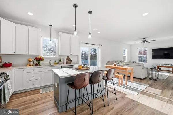 a room with stainless steel appliances kitchen island granite countertop furniture and a view of living room