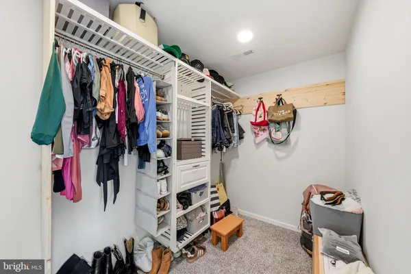 a view of walk in closet with clothes and shoes