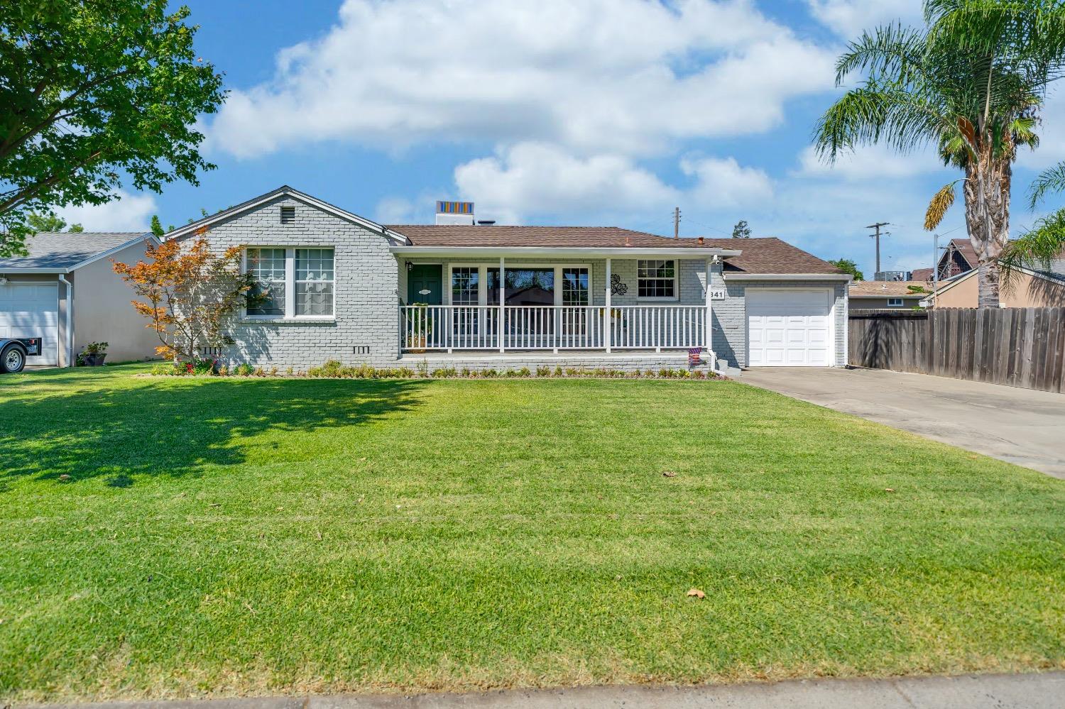 a front view of a house with a yard and potted plants