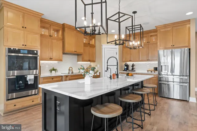 a kitchen with refrigerator and chairs