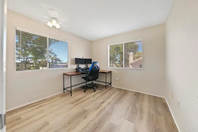 a view of a workspace with furniture and a window