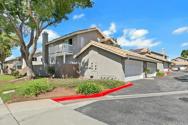 a view of a house with a yard and street
