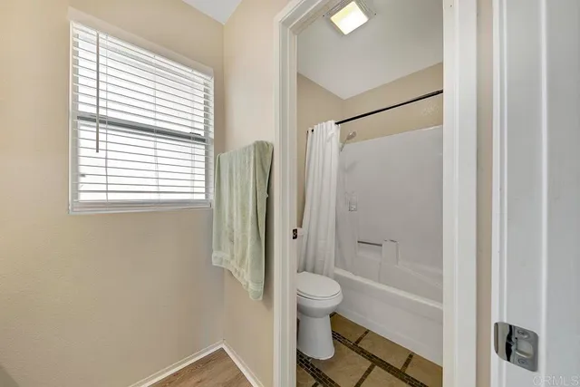 a bathroom with a granite countertop bathtub shower and toilet