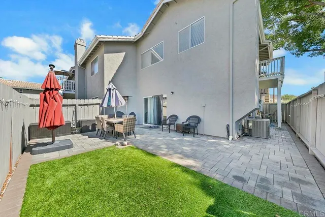 a view of a house with backyard and sitting area