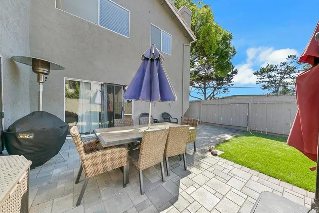 a view of a patio with table and chairs a barbeque with wooden fence