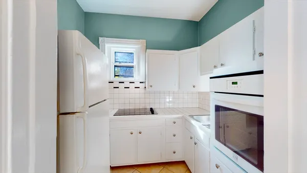 a kitchen with a refrigerator sink and cabinets