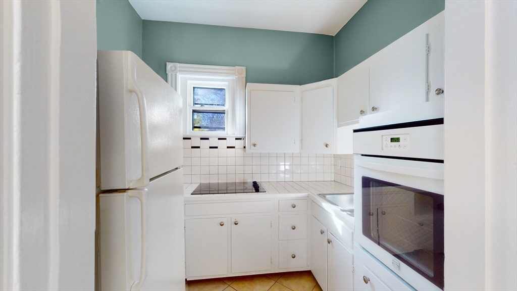 119 Park Street, Unit 3 Brookline, MA 02446 - Photo 3 of 10 a kitchen with a refrigerator sink and cabinets