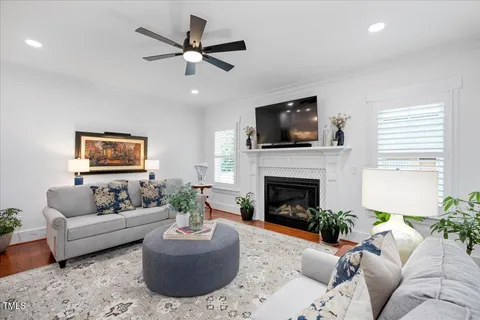 a living room with furniture a flat screen tv and a fireplace