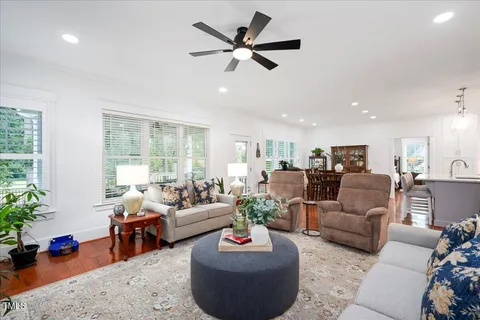 a living room with furniture ceiling fan and a window