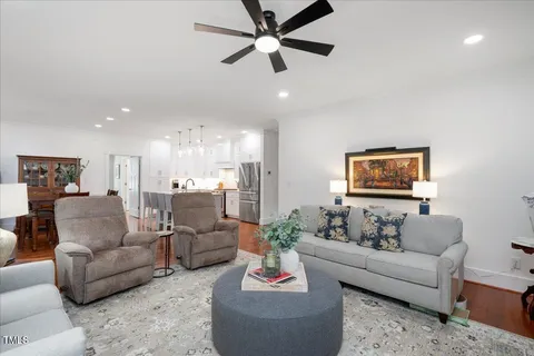 a living room with furniture and a view of kitchen