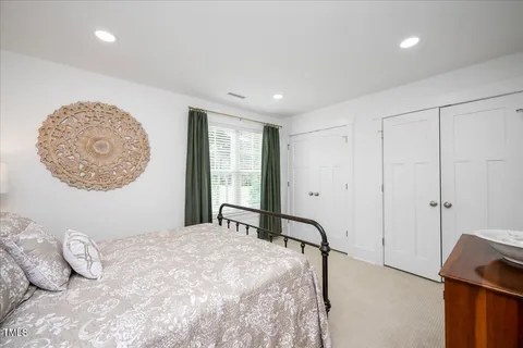 a bedroom with a large bed and a chandelier
