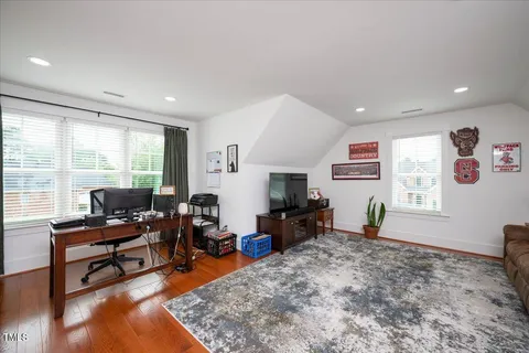 a living room with furniture flat screen tv and a large window