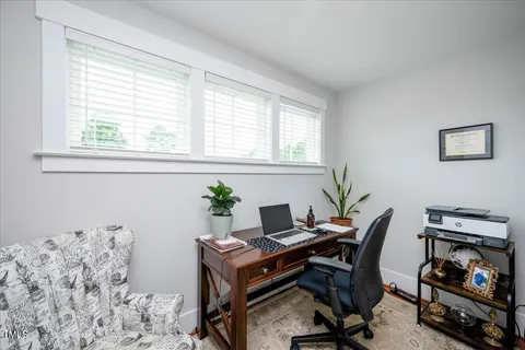 a view of a workspace with furniture and a window