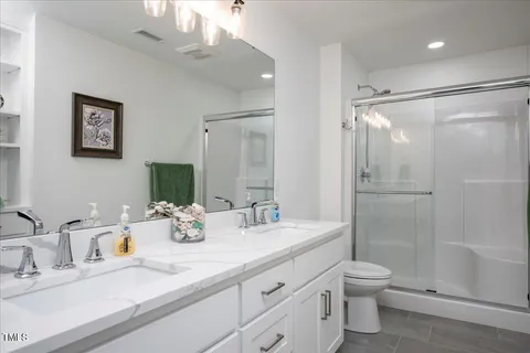 a bathroom with a sink a toilet and shower