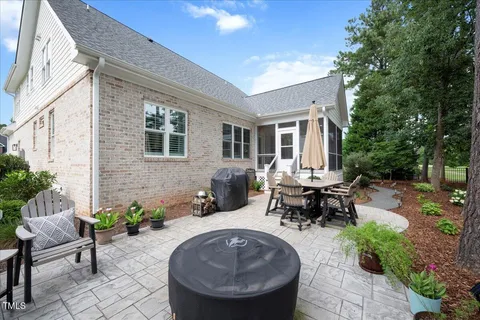 a view of a patio with table and chairs potted plants and a large tree