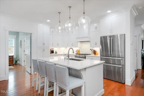 a kitchen with kitchen island a sink stove and refrigerator