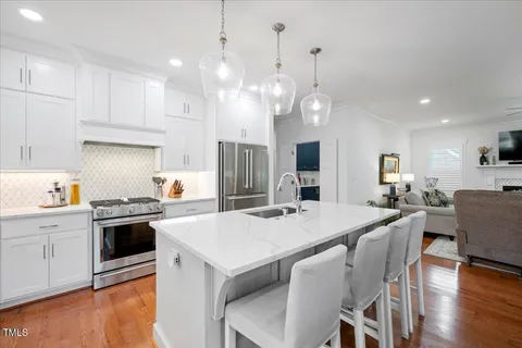 a kitchen with kitchen island a stove a table and chairs