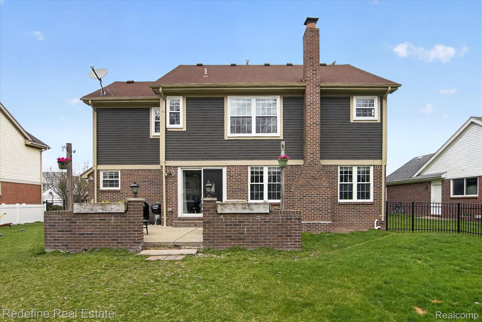 45663 Radnor Road Canton, MI 48187 - Photo 37 of 51 Back of property with a fenced backyard, brick siding, a patio, and a chimney
