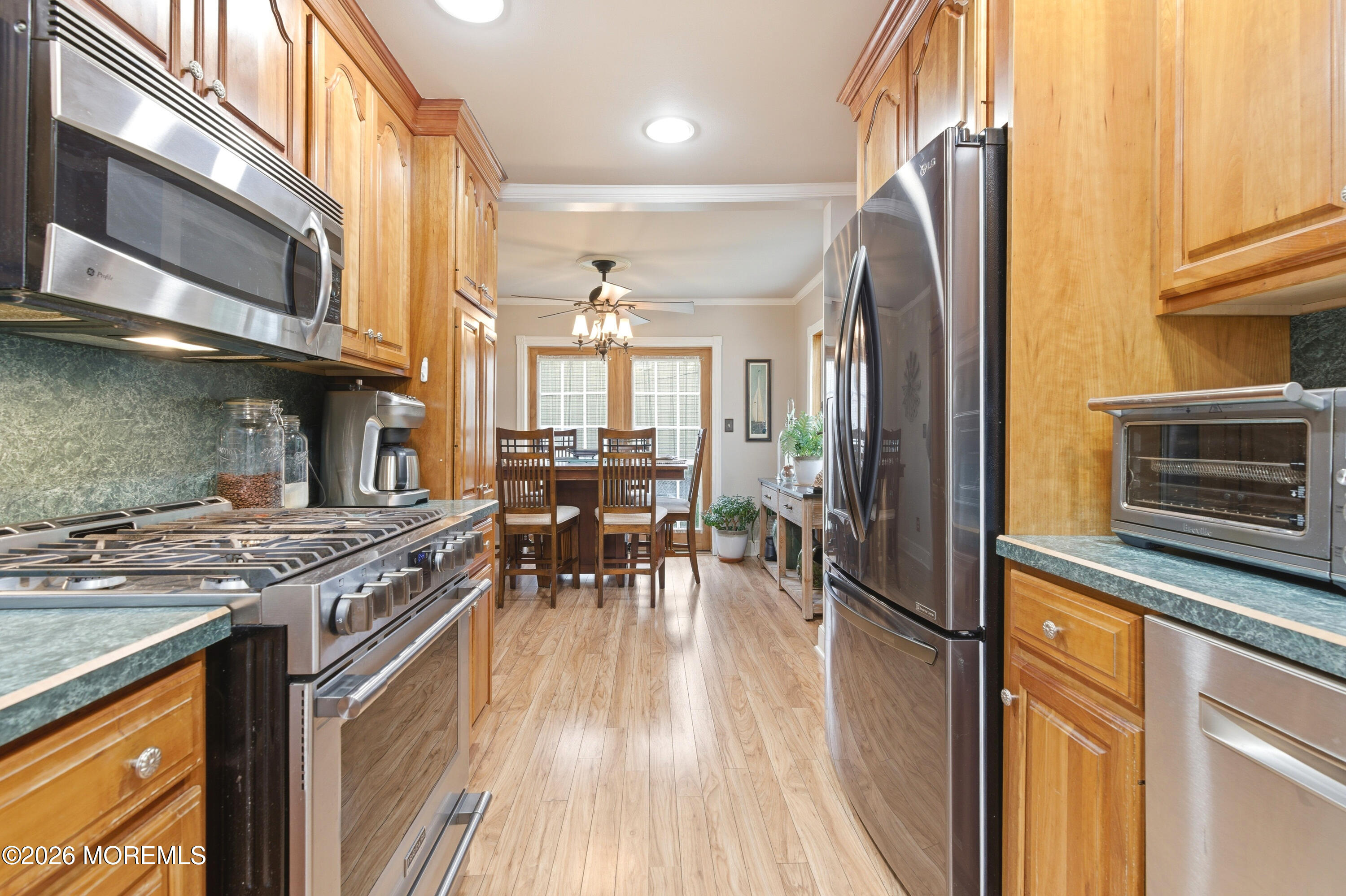 114 Ocean Boulevard Keyport, NJ 07735 - Photo 13 of 41 a kitchen with stainless steel appliances granite countertop a stove top oven a sink dishwasher a dining table and chairs with wooden floor