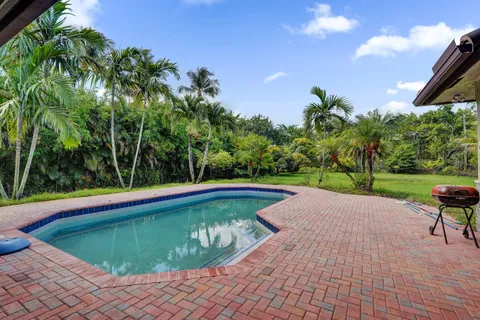 a swimming pool with outdoor seating and garden