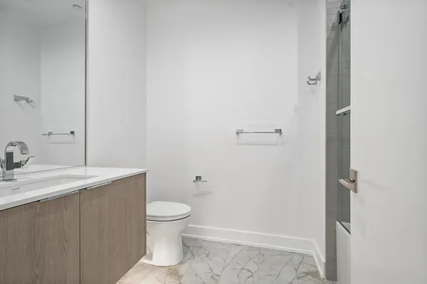 a bathroom with a granite countertop sink toilet and a mirror