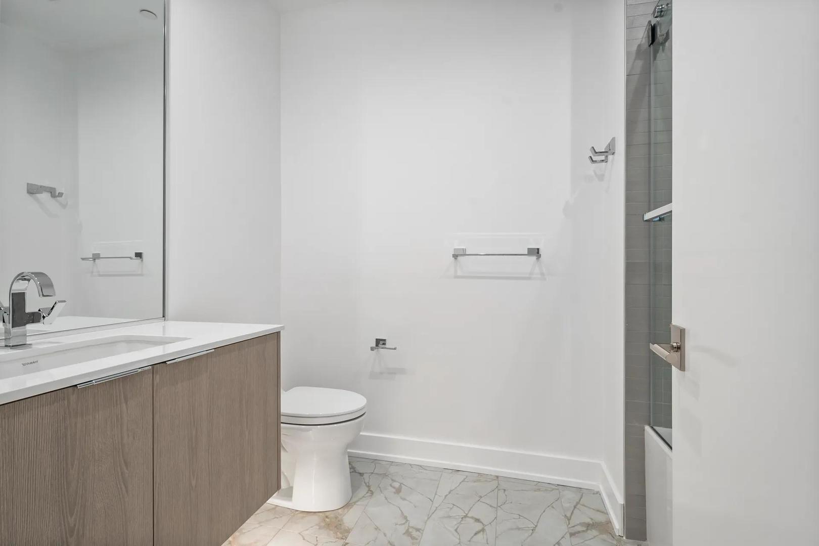 728 Waukegan Road, Unit 206 Deerfield, IL 60015 - Photo 13 of 18 a bathroom with a granite countertop sink toilet and a mirror