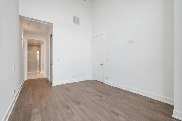 an empty room with wooden floor & closet
