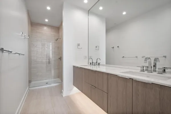 a bathroom with a double vanity sink mirror double and shower