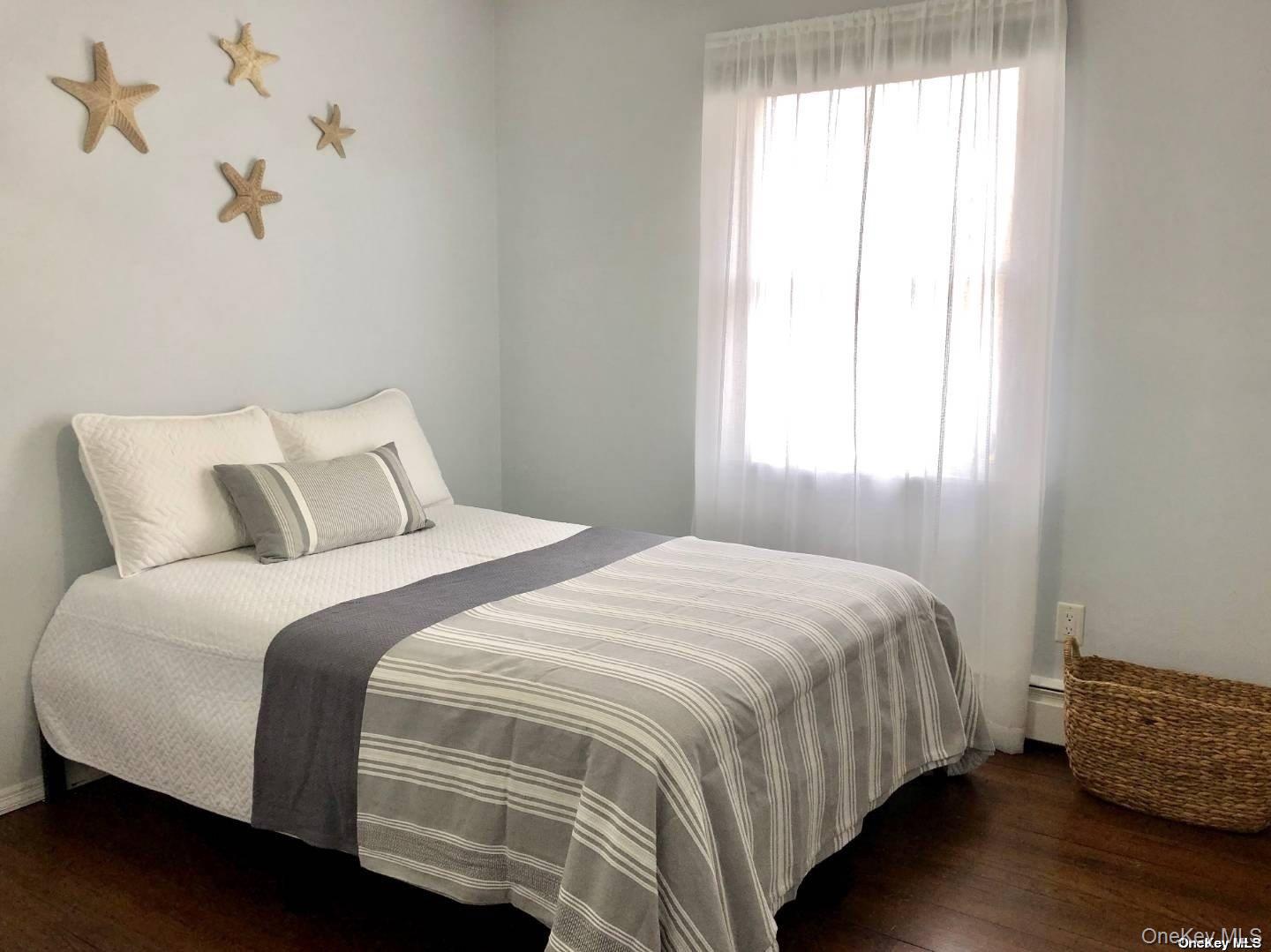 114 Spinney Road East Quogue, NY 11942 - Photo 8 of 15 a bedroom with a bed and a window