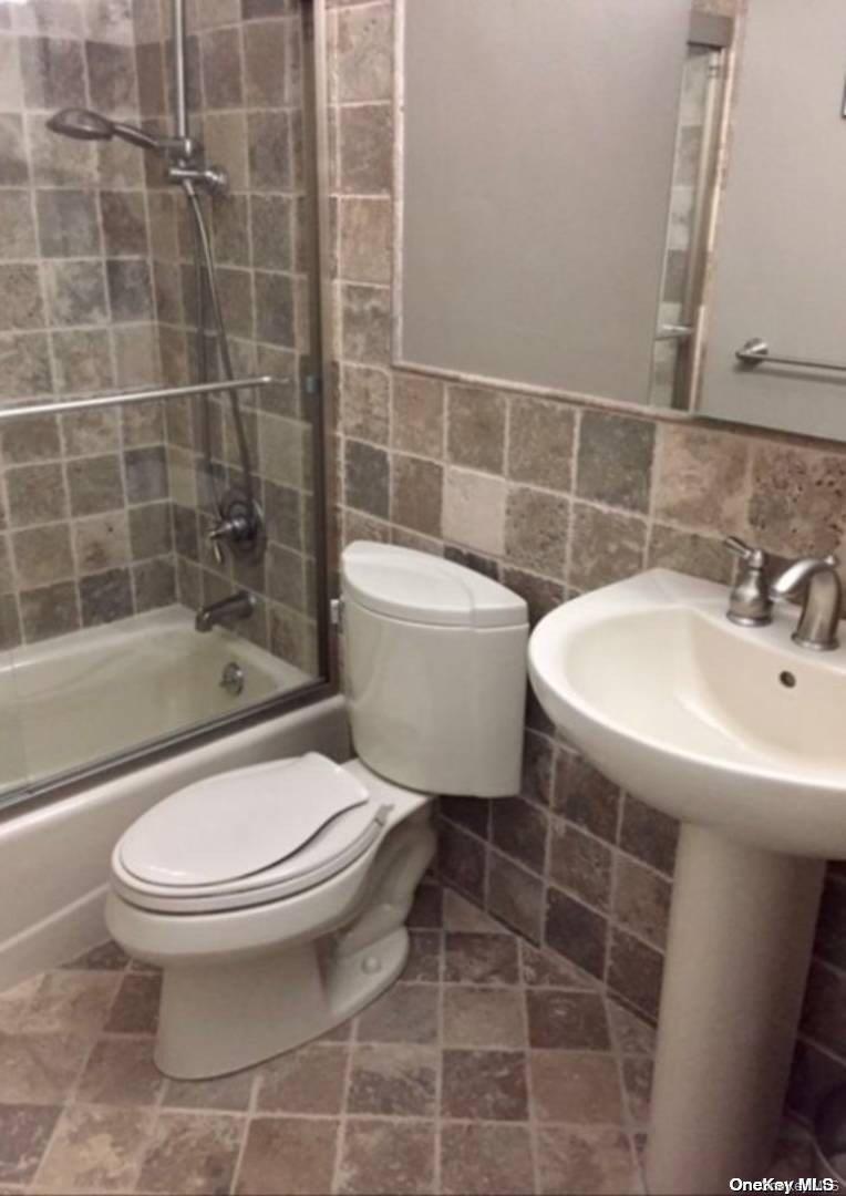 114 Spinney Road East Quogue, NY 11942 - Photo 10 of 15 a white toilet sitting next to a bathroom sink