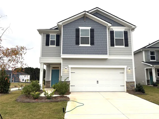 a front view of a house with a yard garage and outdoor seating