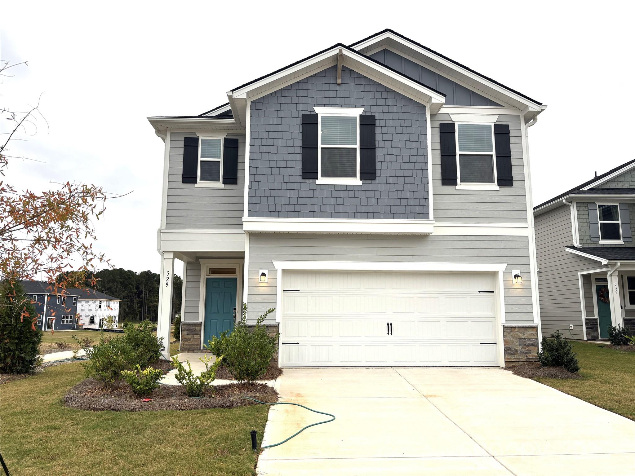 a front view of a house with a yard garage and outdoor seating