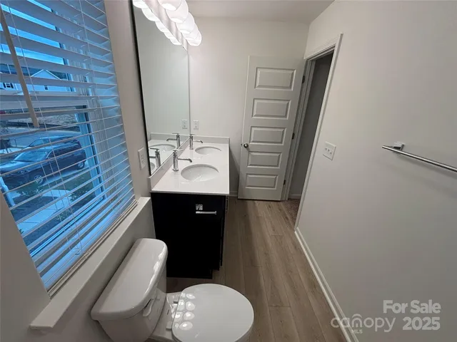 a bathroom with a sink a toilet a mirror and vanity