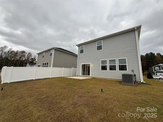 a front view of house with yard and trees in the background