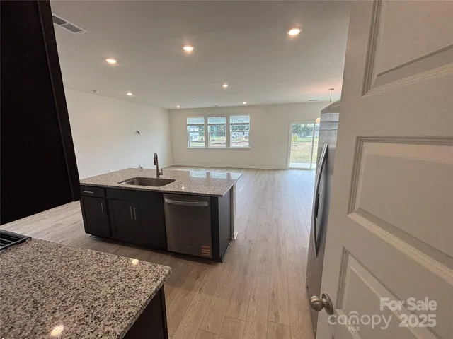a kitchen with stainless steel appliances granite countertop a refrigerator and a sink