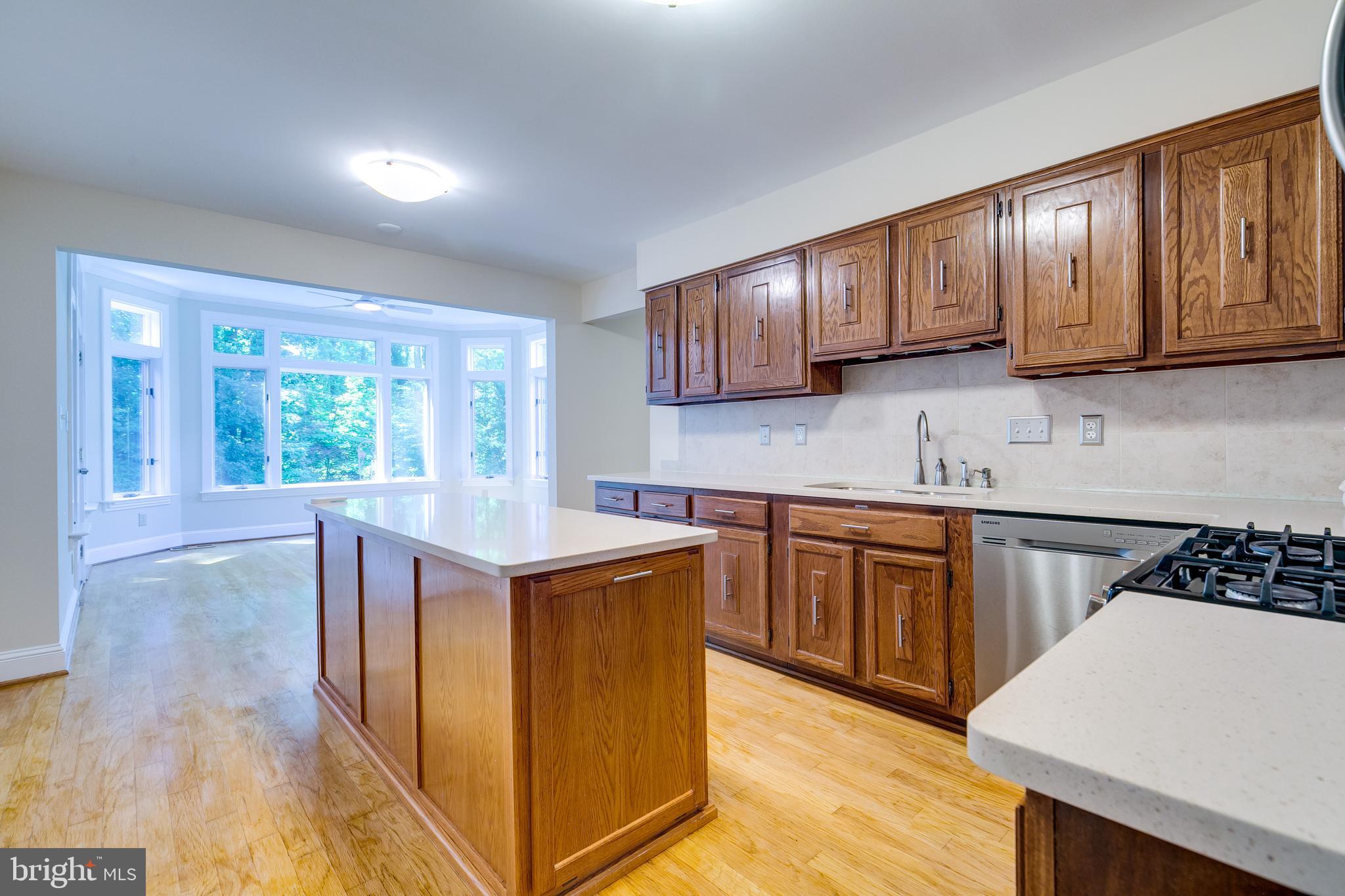 7007 Barnacle Place Burke, VA 22015 - Photo 13 of 49 a kitchen with granite countertop wooden cabinets a stove a sink and a window