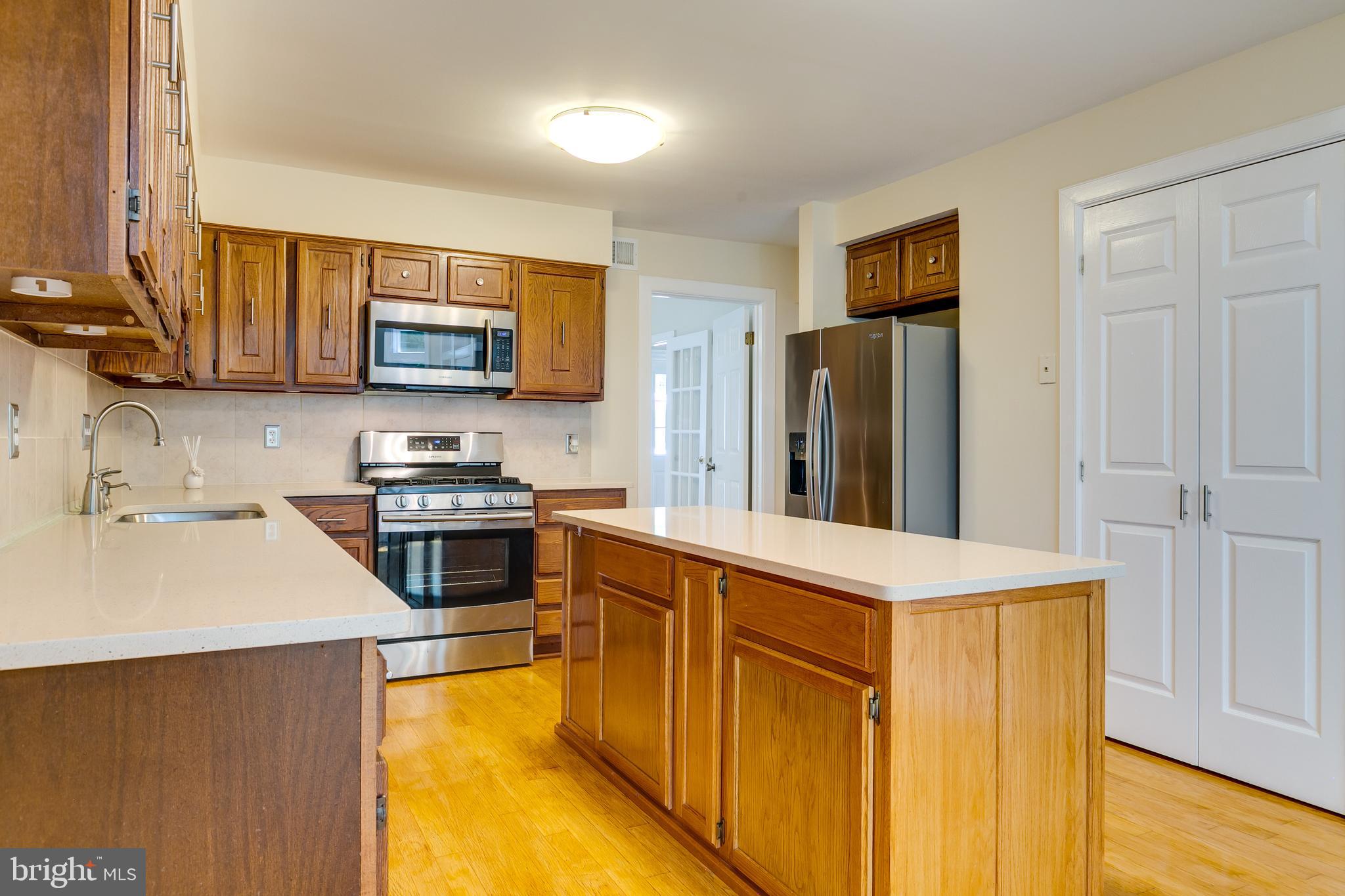 7007 Barnacle Place Burke, VA 22015 - Photo 16 of 49 a kitchen with stainless steel appliances a stove microwave and a refrigerator