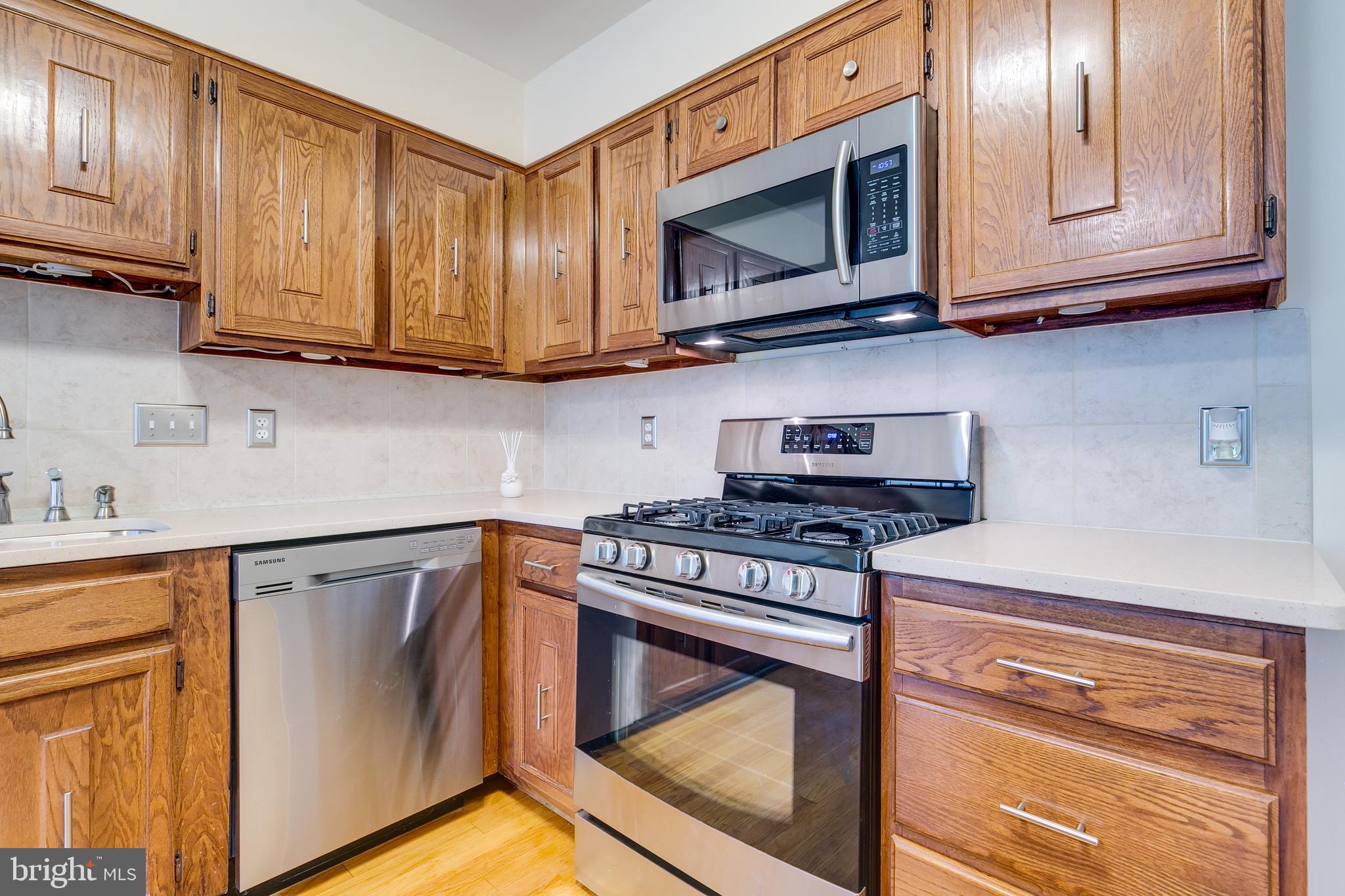 7007 Barnacle Place Burke, VA 22015 - Photo 17 of 49 a kitchen with granite countertop cabinets stainless steel appliances and wooden floor
