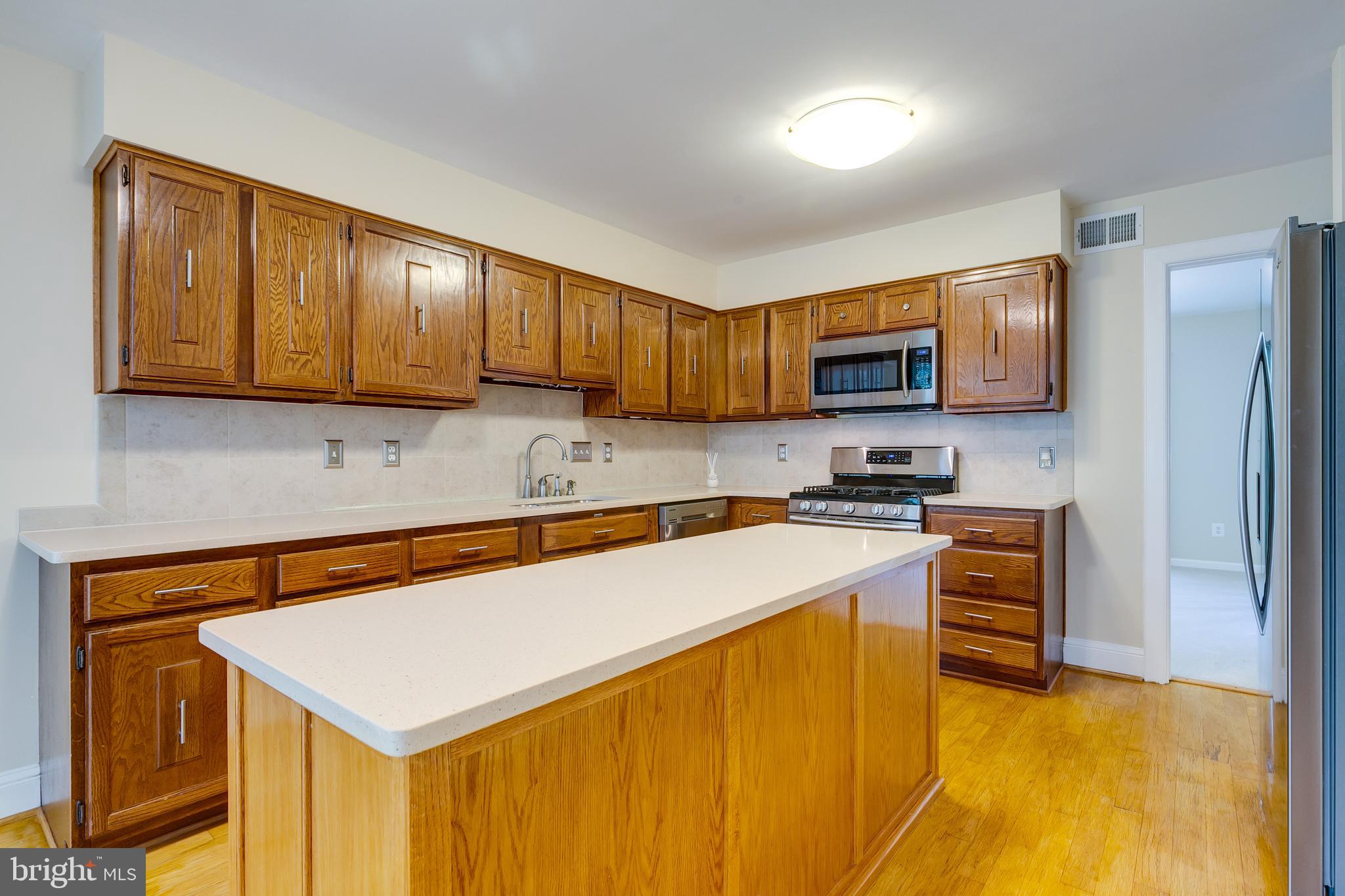 7007 Barnacle Place Burke, VA 22015 - Photo 18 of 49 a kitchen that has a sink a stove and a refrigerator
