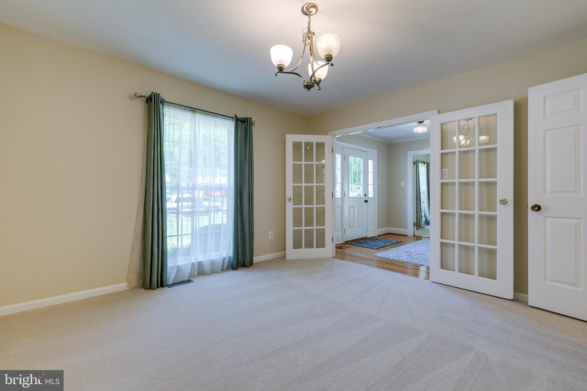 7007 Barnacle Place Burke, VA 22015 - Photo 9 of 49 an empty room with chandelier and windows