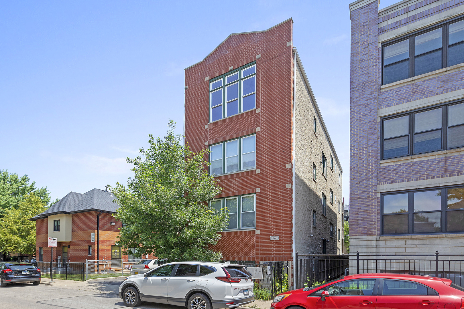 1267 North Honore Street, Unit 3 Chicago, IL 60622 - Photo 14 of 17 a front view of a building with lot of cars and trees