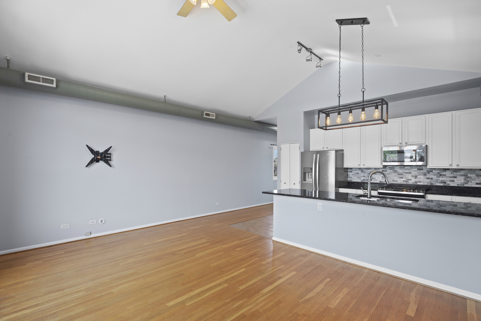 1267 North Honore Street, Unit 3 Chicago, IL 60622 - Photo 3 of 17 a kitchen with stainless steel appliances granite countertop a sink a stove and a wooden floor